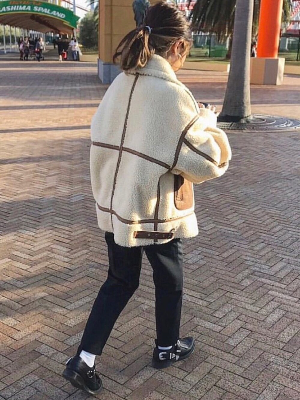 ブラウン系のミリタリージャケットを着用したレディースの冬コーディネートの1枚目の写真