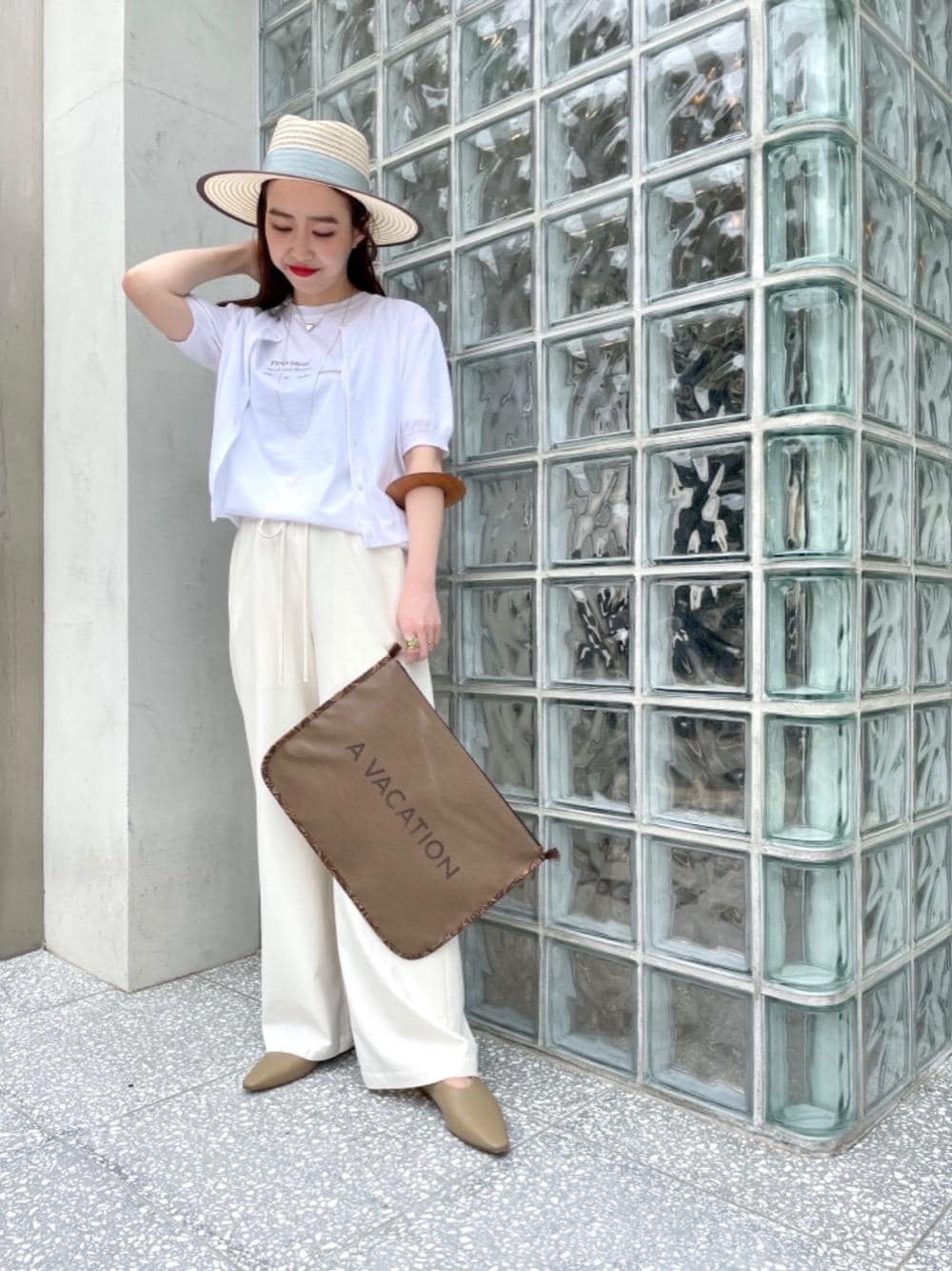 ホワイト系のカーディガン/ボレロ、ホワイト系のその他パンツ、ブラウン系のクラッチバッグを着用したレディースの春コーディネートの1枚目の写真