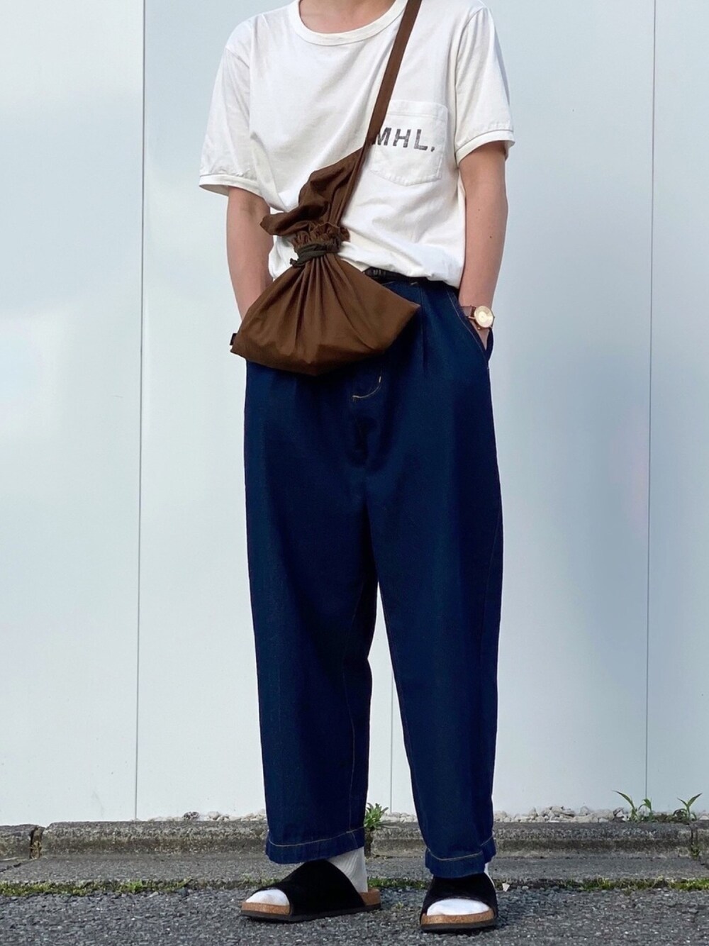 ホワイト系のTシャツ/カットソー、ブルー系のデニムパンツ、ブラック系のサンダルを着用したメンズの夏コーディネートの1枚目の写真