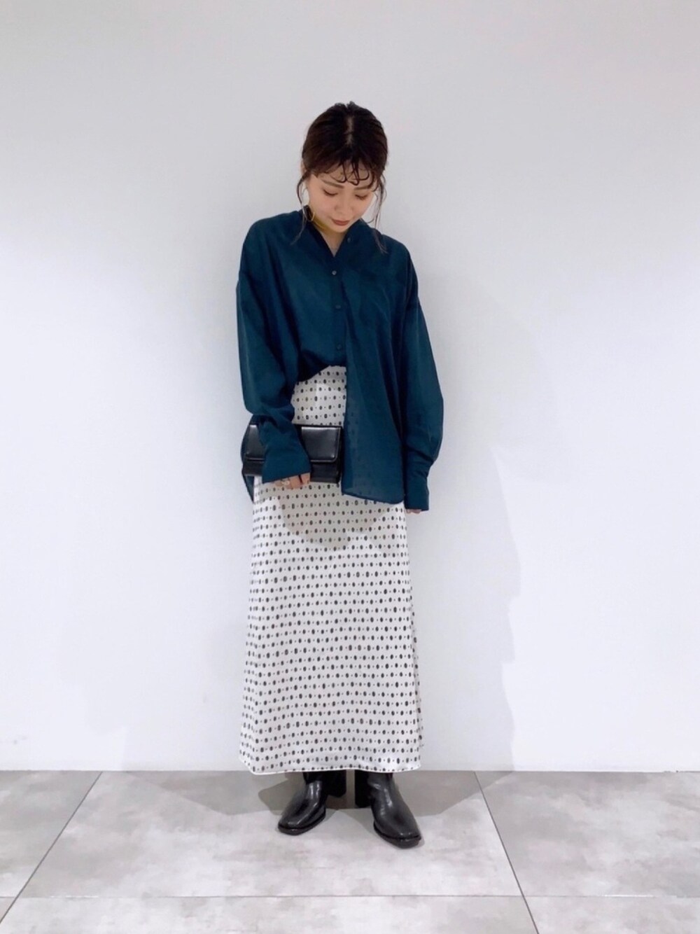 グレー系のスカート、ブラック系のショルダーバッグ、グリーン系のTシャツ/カットソーを着用したレディースの夏コーディネートの1枚目の写真