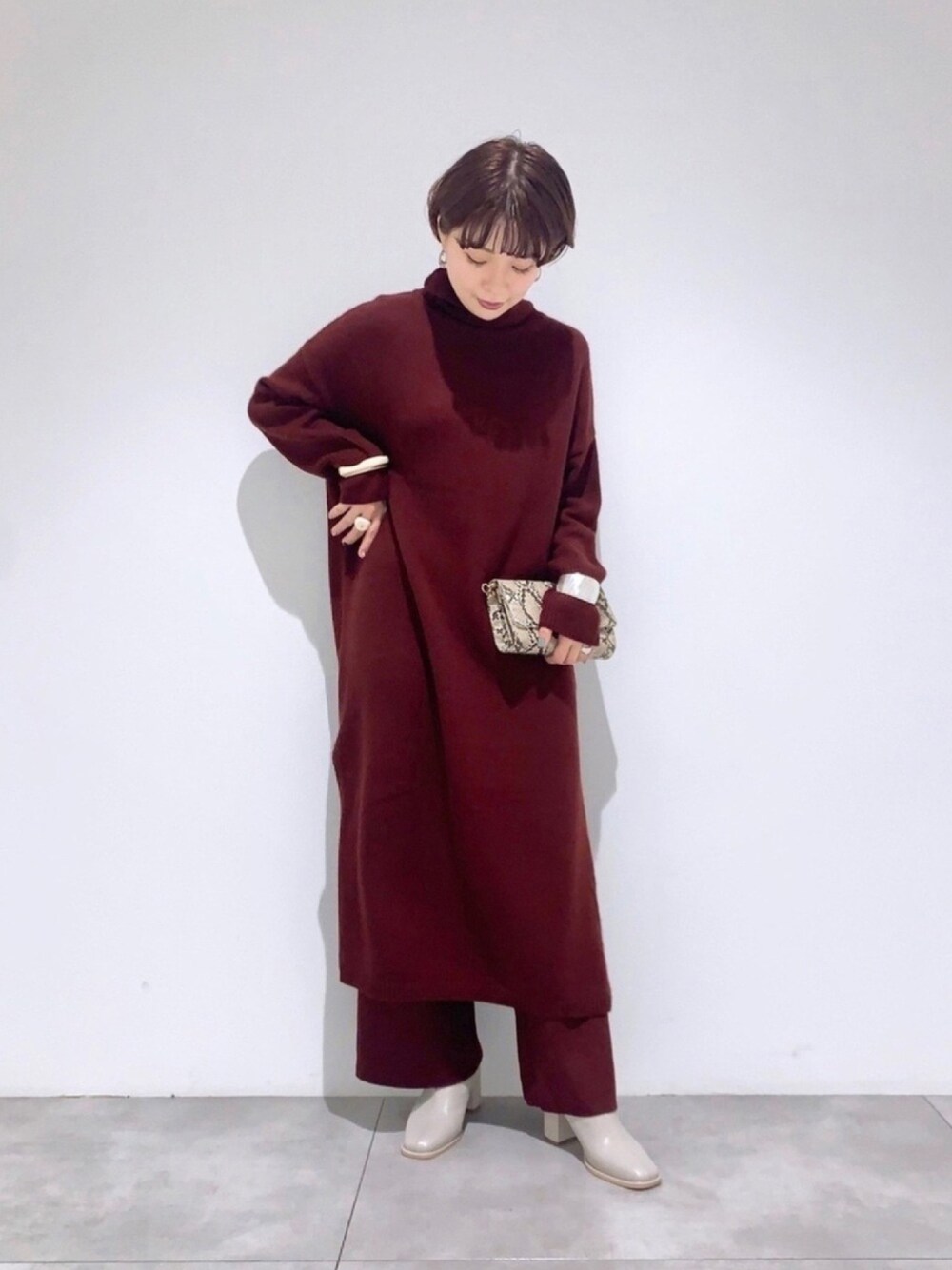 レッド系のワンピース、レッド系のその他パンツ、その他のショルダーバッグを着用したレディースの秋コーディネートの1枚目の写真