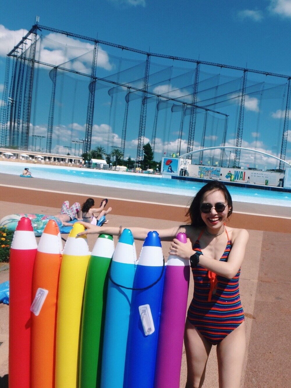 オレンジ系の水着を着用したレディースの夏コーディネートの1枚目の写真