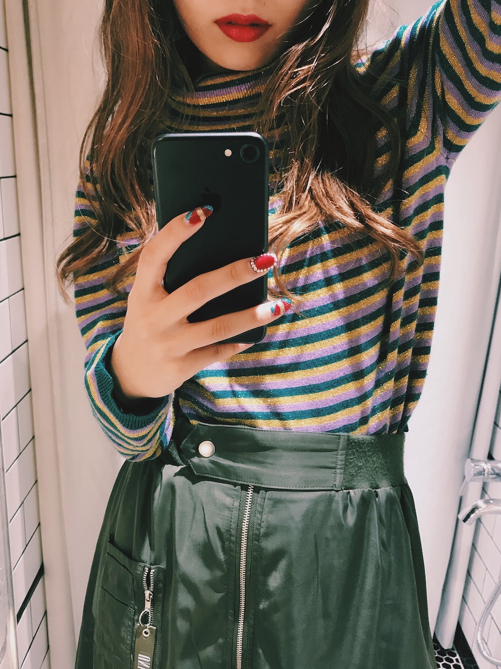 グリーン系のニット/セーター、グリーン系のスカートを着用したレディースの秋コーディネートの1枚目の写真