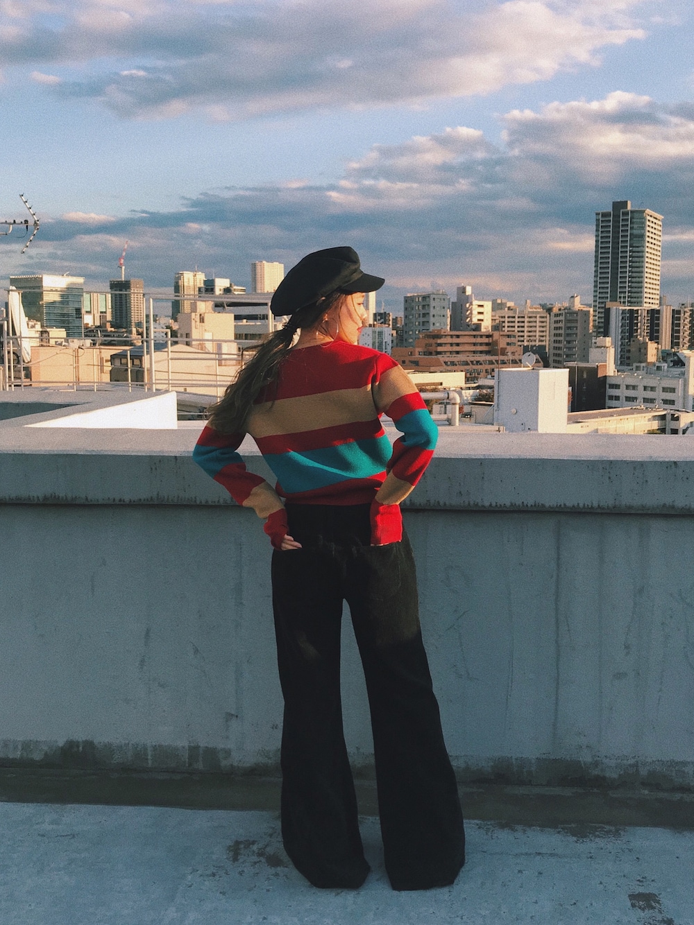 レッド系のニット/セーター、ブラック系のその他パンツを着用したレディースの冬コーディネートの1枚目の写真