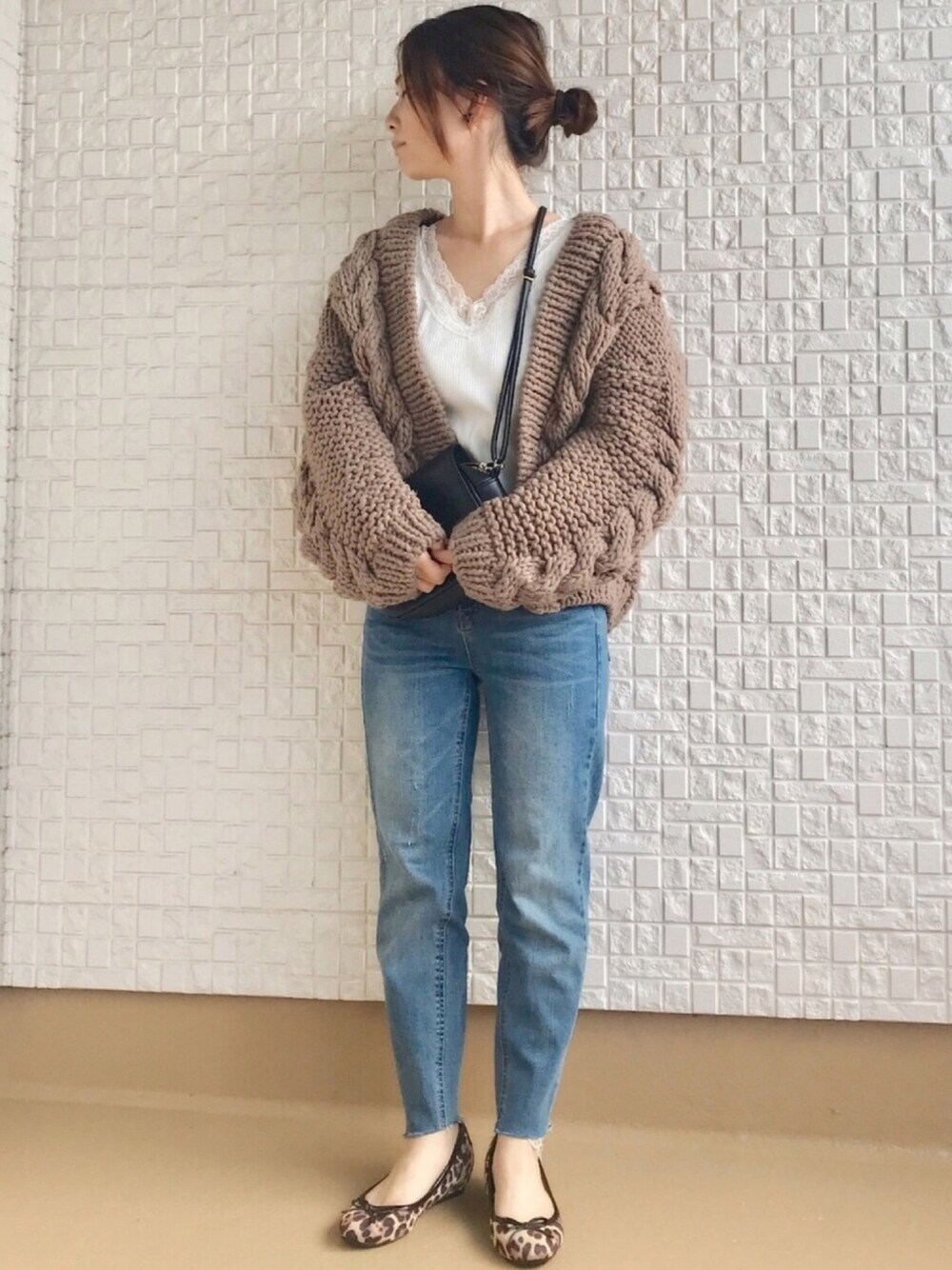 ベージュ系のカーディガン/ボレロ、ブラウン系のパンプス、ブラック系のイヤリングを着用したレディースの秋コーディネートの1枚目の写真