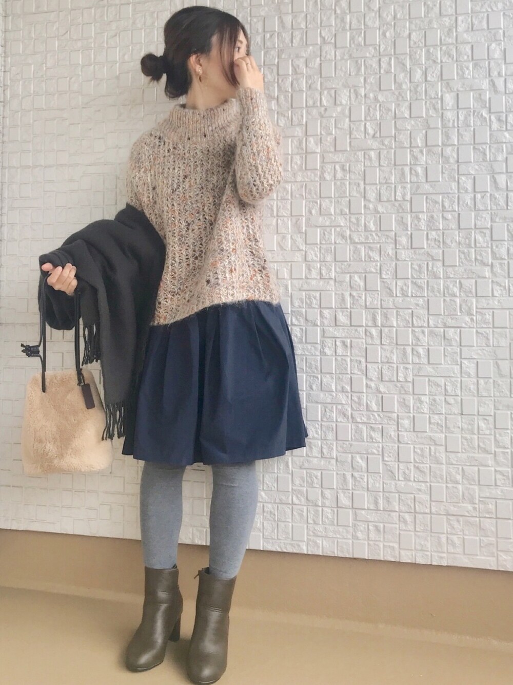 イエロー系のニット/セーター、ブルー系のスカート、ブラウン系のブーツを着用したレディースの冬コーディネートの1枚目の写真