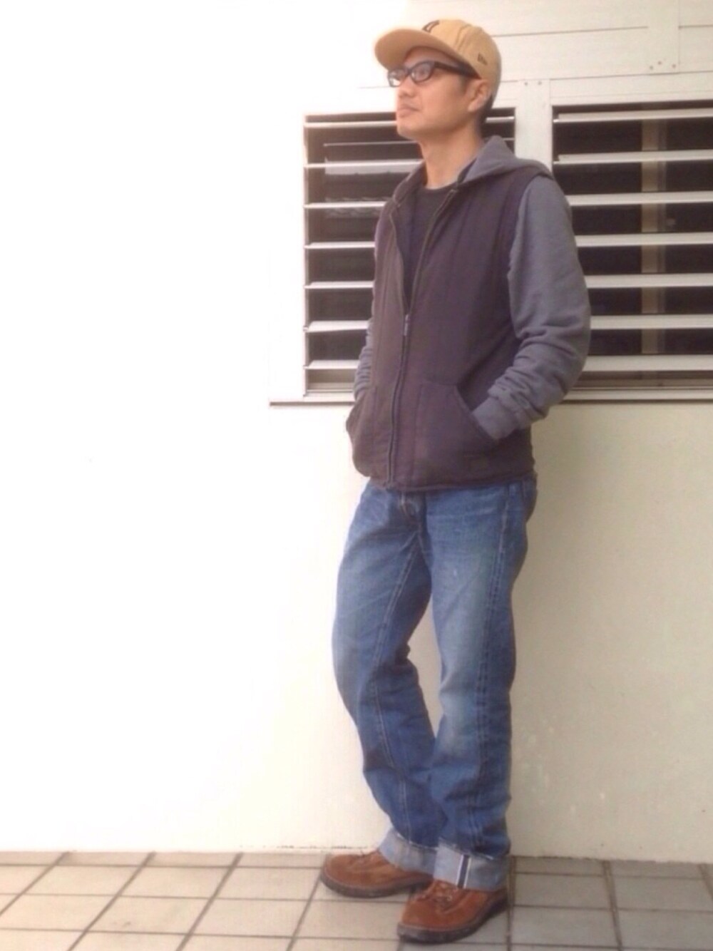 ブルー系のデニムパンツ、ブラック系のその他アウター、ブラウン系のブーツを着用したメンズの春コーディネートの1枚目の写真