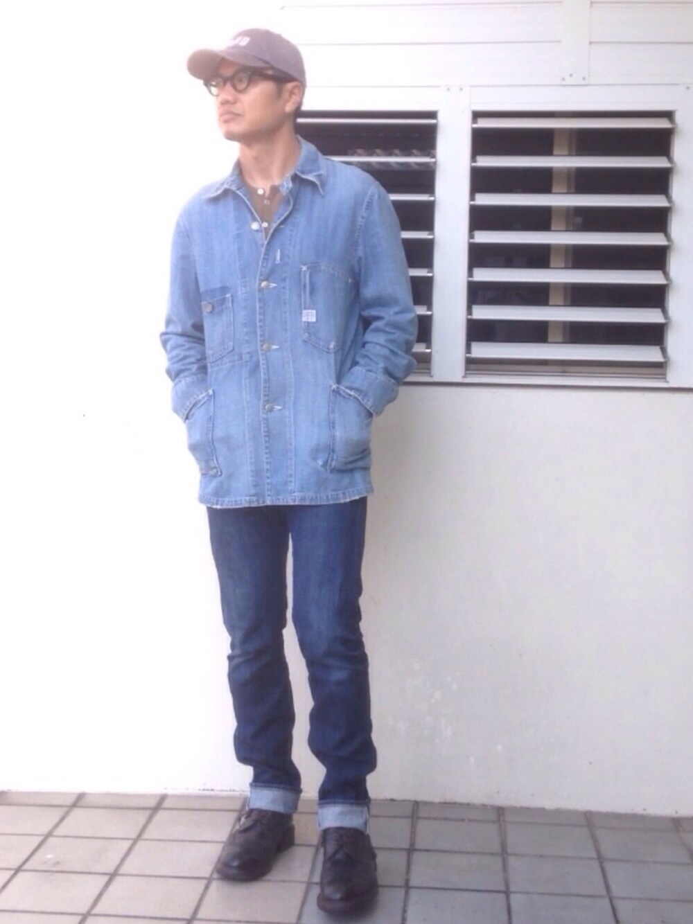 ブラック系のブーツ、ブルー系のカバーオール、グリーン系のTシャツ/カットソーを着用したメンズの春コーディネートの1枚目の写真