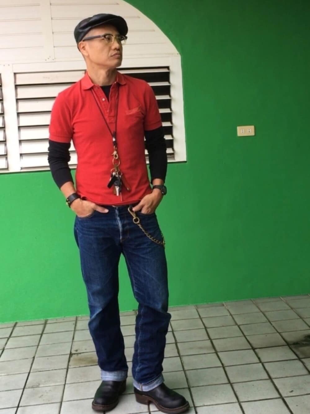 レッド系のポロシャツ、ブラック系のブーツ、ブラック系のTシャツ/カットソーを着用したメンズの秋コーディネートの1枚目の写真