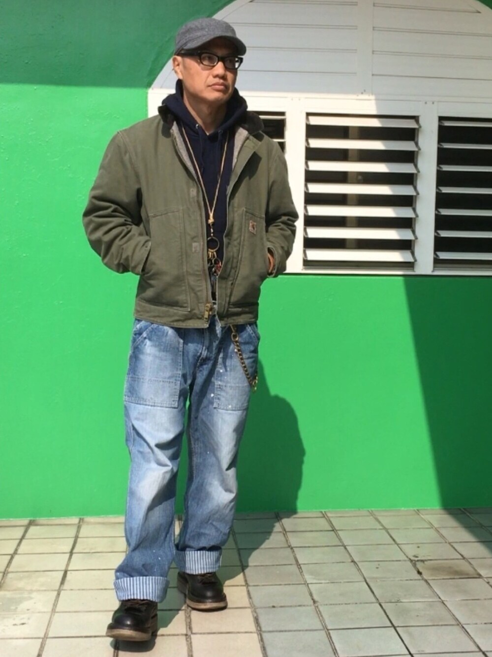 ブルー系のパーカー、グリーン系のカバーオール、ブルー系のデニムパンツを着用したメンズの冬コーディネートの1枚目の写真