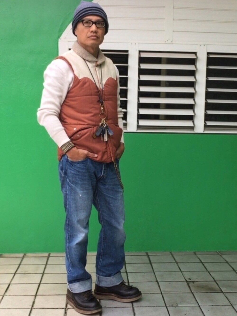 ブルー系のデニムパンツ、ブラウン系のベスト、ブラック系のブーツを着用したメンズの春コーディネートの1枚目の写真