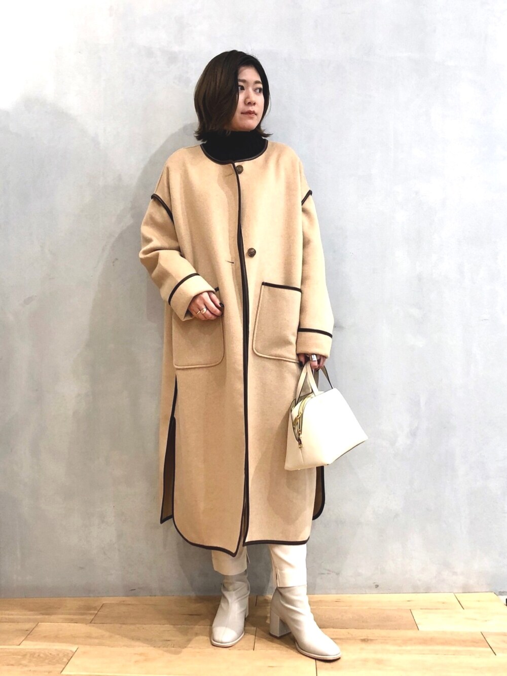 ブラック系のニット/セーター、ベージュ系のノーカラージャケット、ホワイト系のその他パンツを着用したレディースの冬コーディネートの1枚目の写真