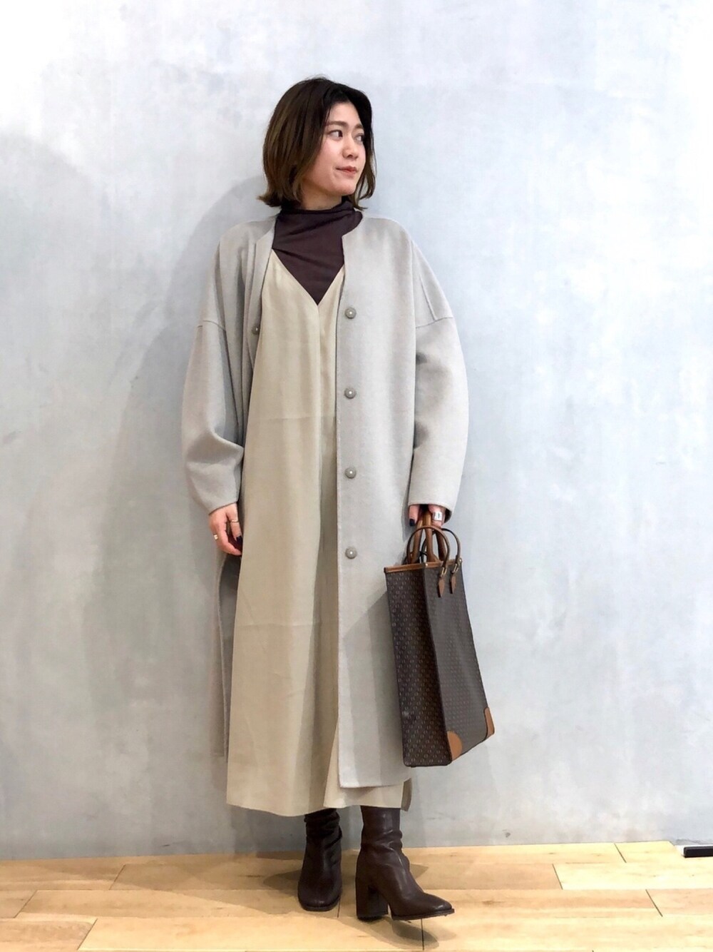 ブラウン系のTシャツ/カットソー、ベージュ系のワンピース、グリーン系のノーカラージャケットを着用したレディースの冬コーディネートの1枚目の写真