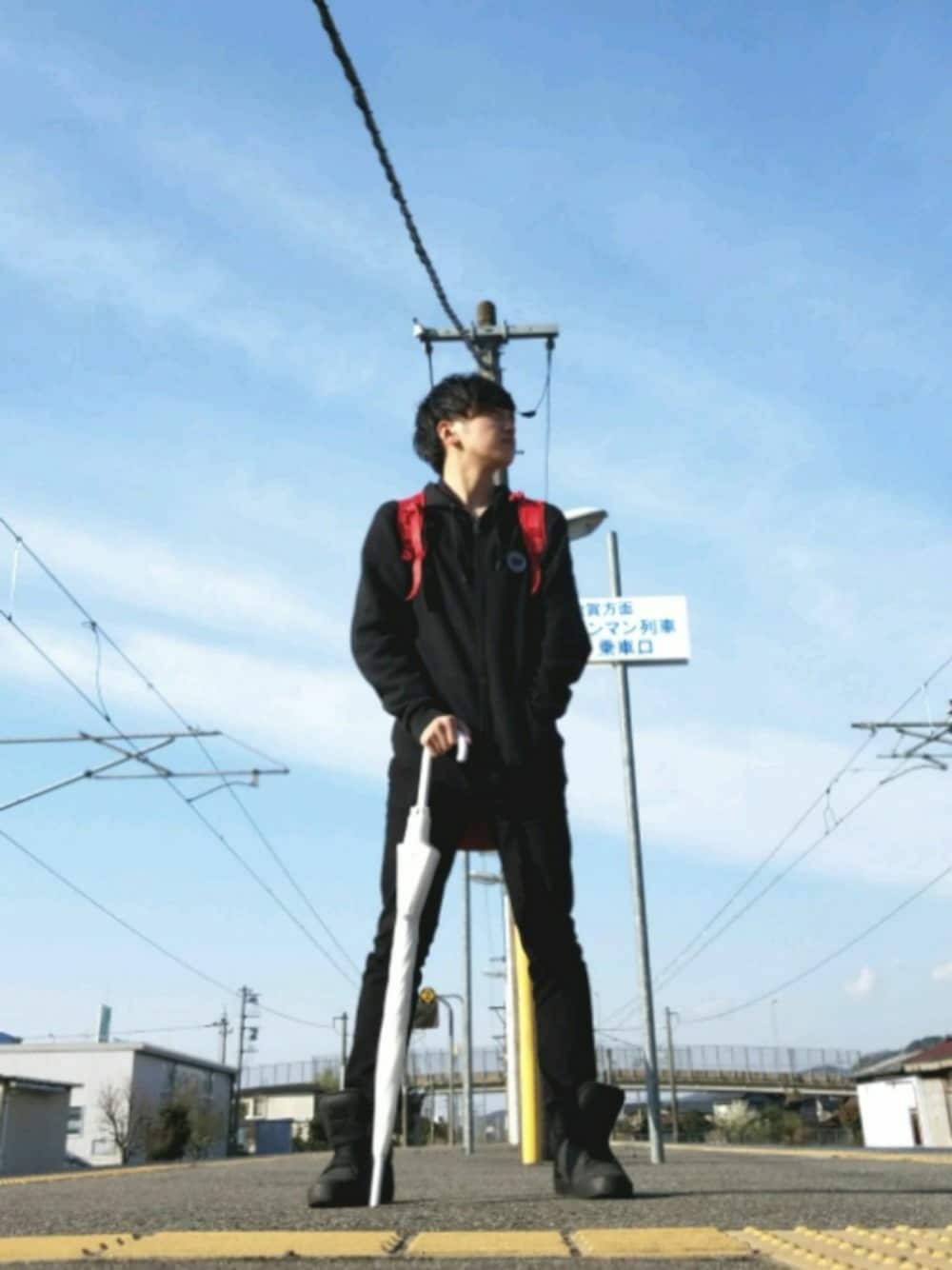 レッド系のバックパック/リュック、ブラック系のパーカー、ブラック系のスニーカーを着用したメンズの春コーディネートの1枚目の写真