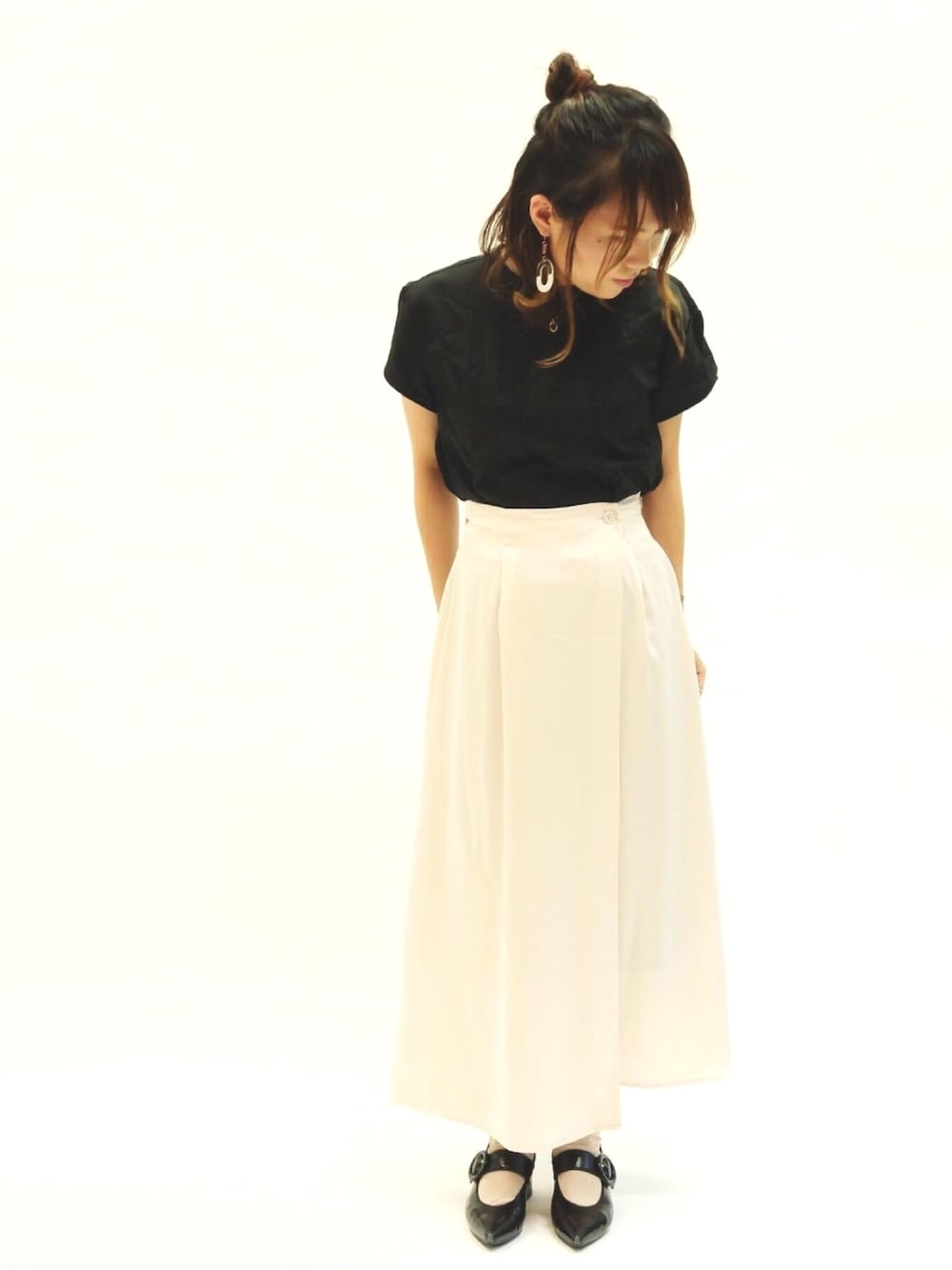 ピンク系のスカート、ブラック系のシャツ/ブラウスを着用したレディースの秋コーディネートの1枚目の写真