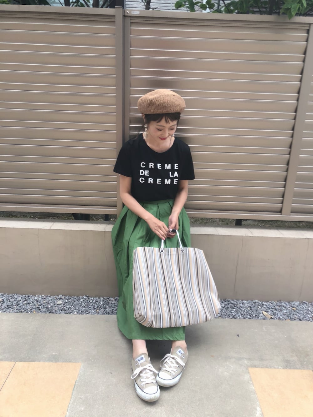 ブラック系のTシャツ/カットソー、グリーン系のスカート、グレー系のトートバッグを着用したレディースの夏コーディネートの1枚目の写真