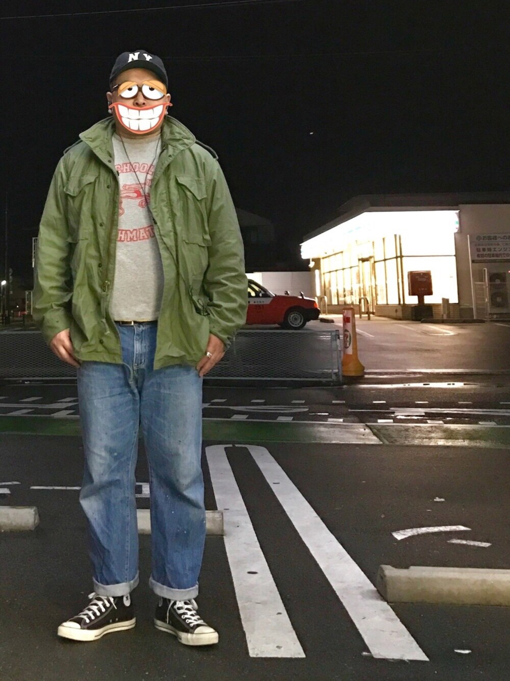 グリーン系のミリタリージャケット、グレー系のTシャツ/カットソー、ブルー系のデニムパンツを着用したメンズの春コーディネートの1枚目の写真