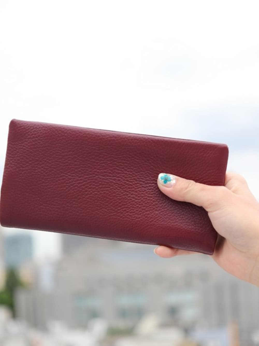 レッド系の財布を着用したレディースの春コーディネートの1枚目の写真