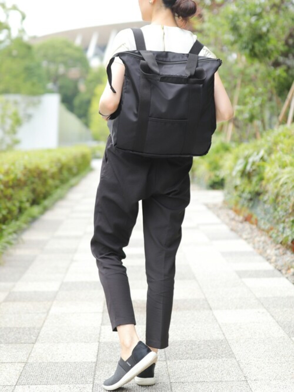 ブラック系のトートバッグを着用したレディースの夏コーディネートの1枚目の写真