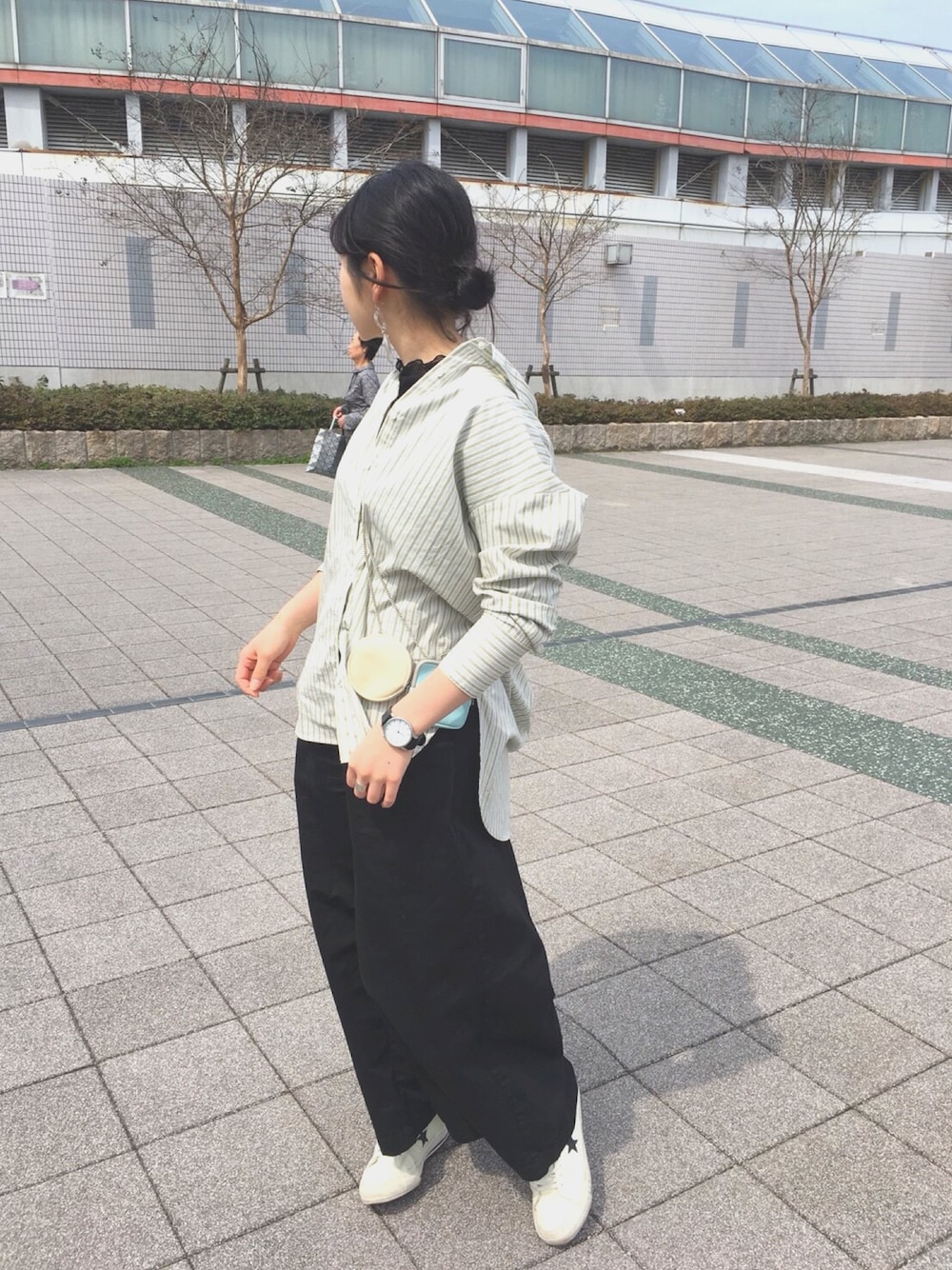 グレー系のシャツ/ブラウス、ブラック系のその他パンツ、ホワイト系のスニーカーを着用したレディースの春コーディネートの1枚目の写真