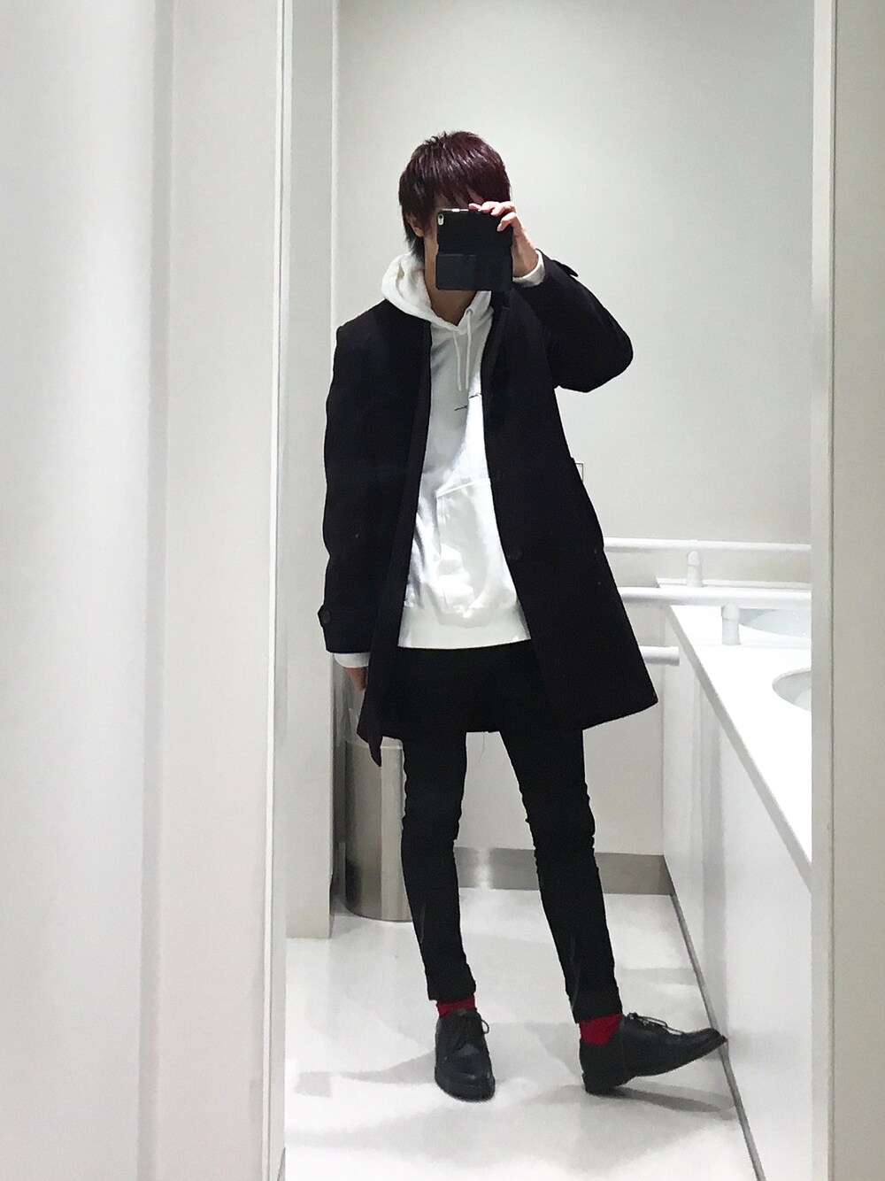 ホワイト系のパーカー、ブラック系のデニムパンツ、ブラック系のドレスシューズを着用したメンズの冬コーディネートの1枚目の写真