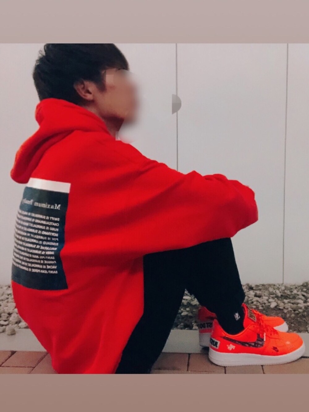 オレンジ系のパーカー、ブラック系のデニムパンツ、オレンジ系のスニーカーを着用したメンズの秋コーディネートの1枚目の写真