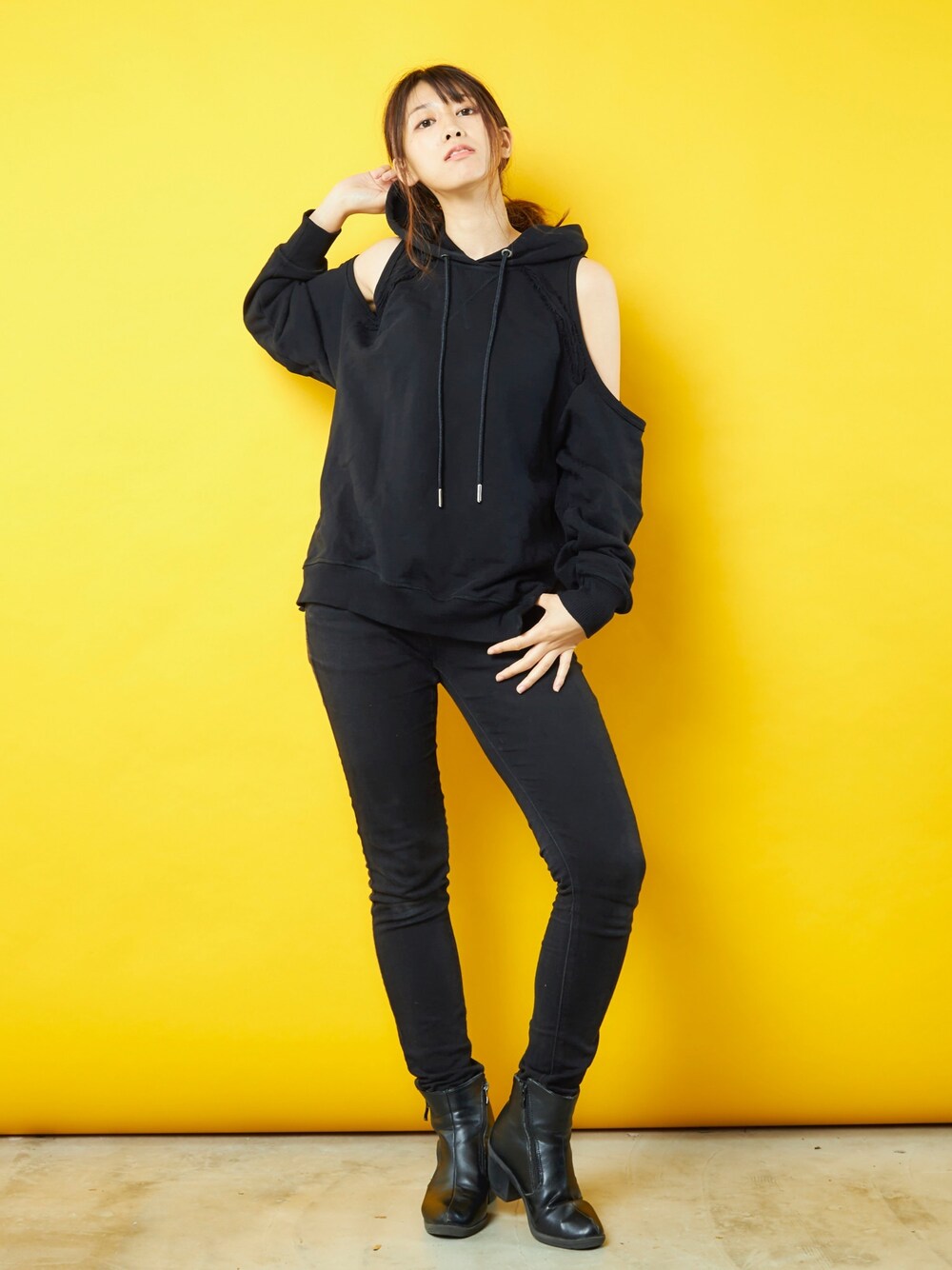 ブラック系のパーカー、ブラック系のデニムパンツを着用したレディースの秋コーディネートの1枚目の写真