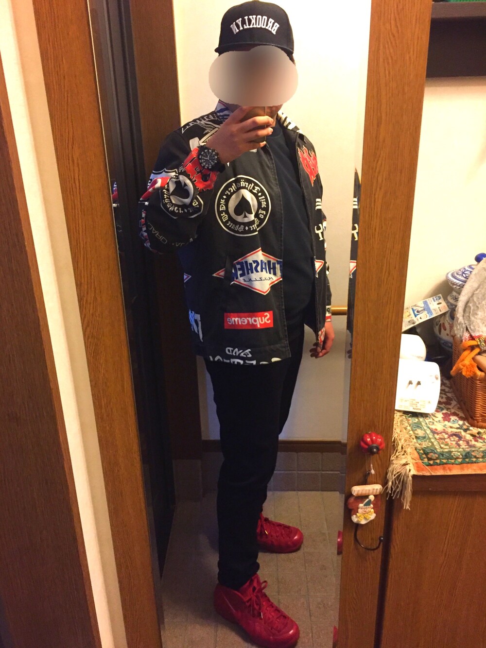 ブラック系のニット/セーター、ブラック系のジャケット/アウター、レッド系のスニーカーを着用したメンズの冬コーディネートの1枚目の写真