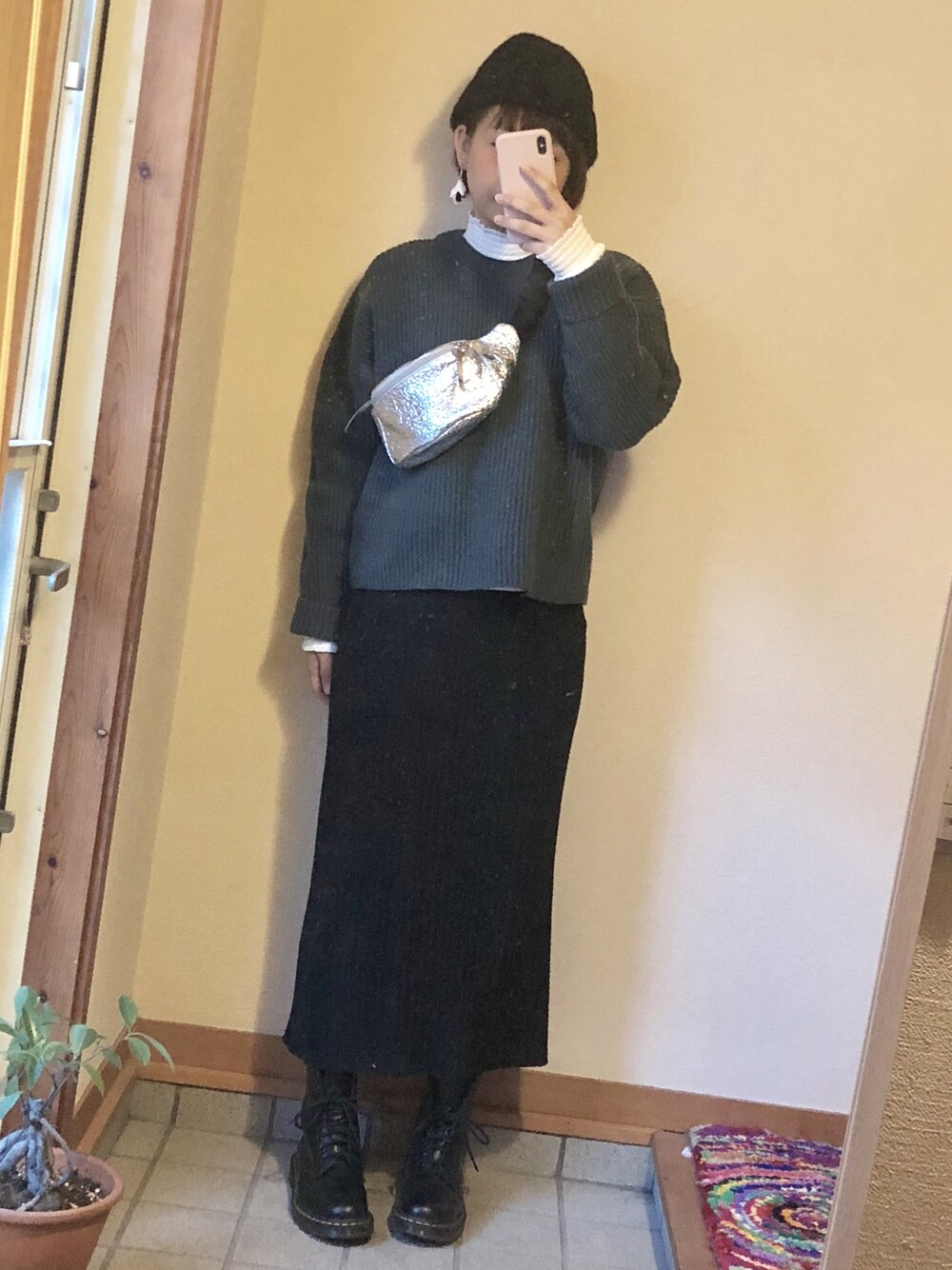 ホワイト系のシャツ/ブラウス、グリーン系のニット/セーター、ブラック系のスカートを着用したレディースの冬コーディネートの1枚目の写真