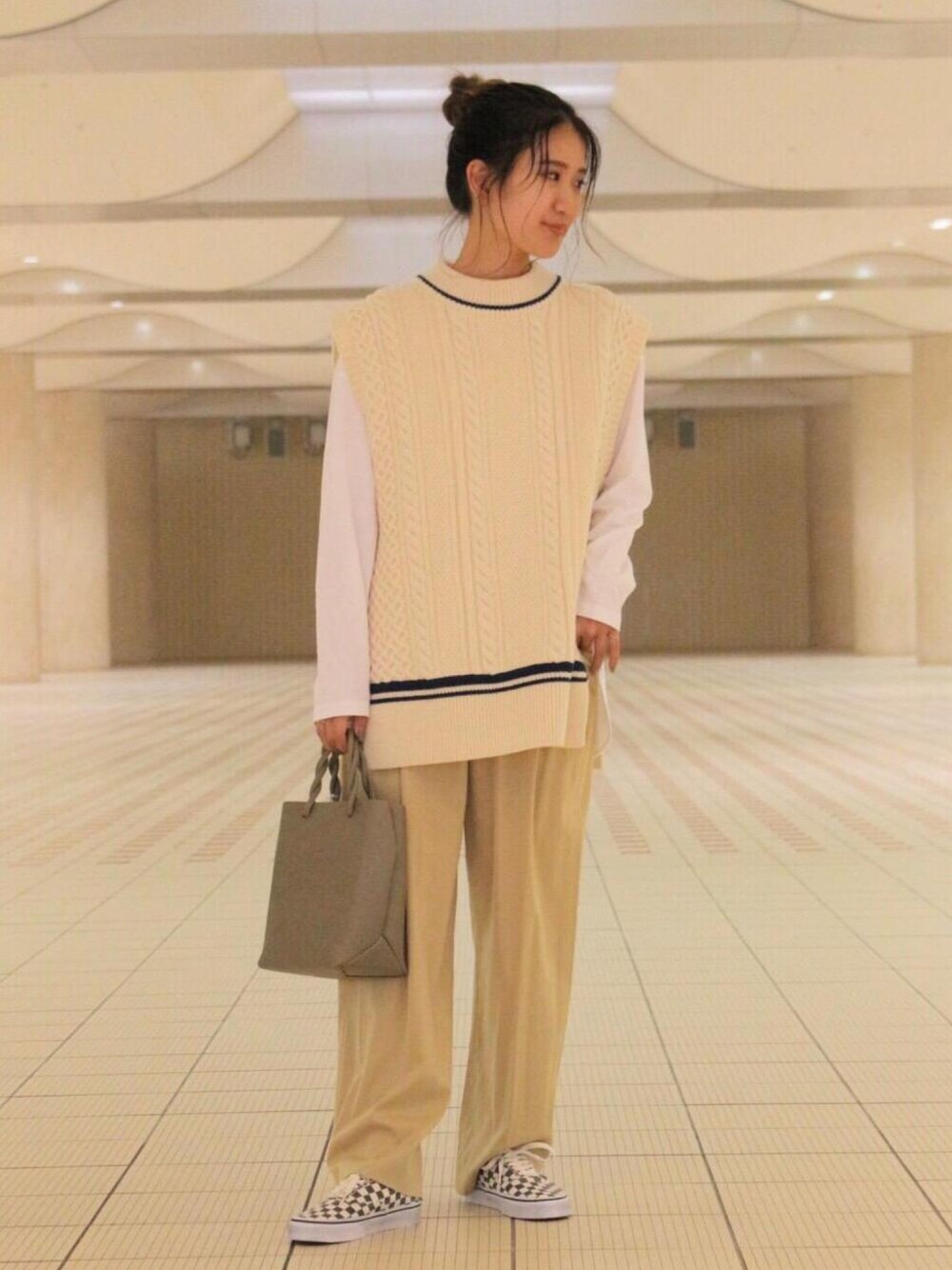 ブラック系のスニーカー、ベージュ系のその他パンツ、グリーン系のショルダーバッグを着用したレディースの秋コーディネートの1枚目の写真