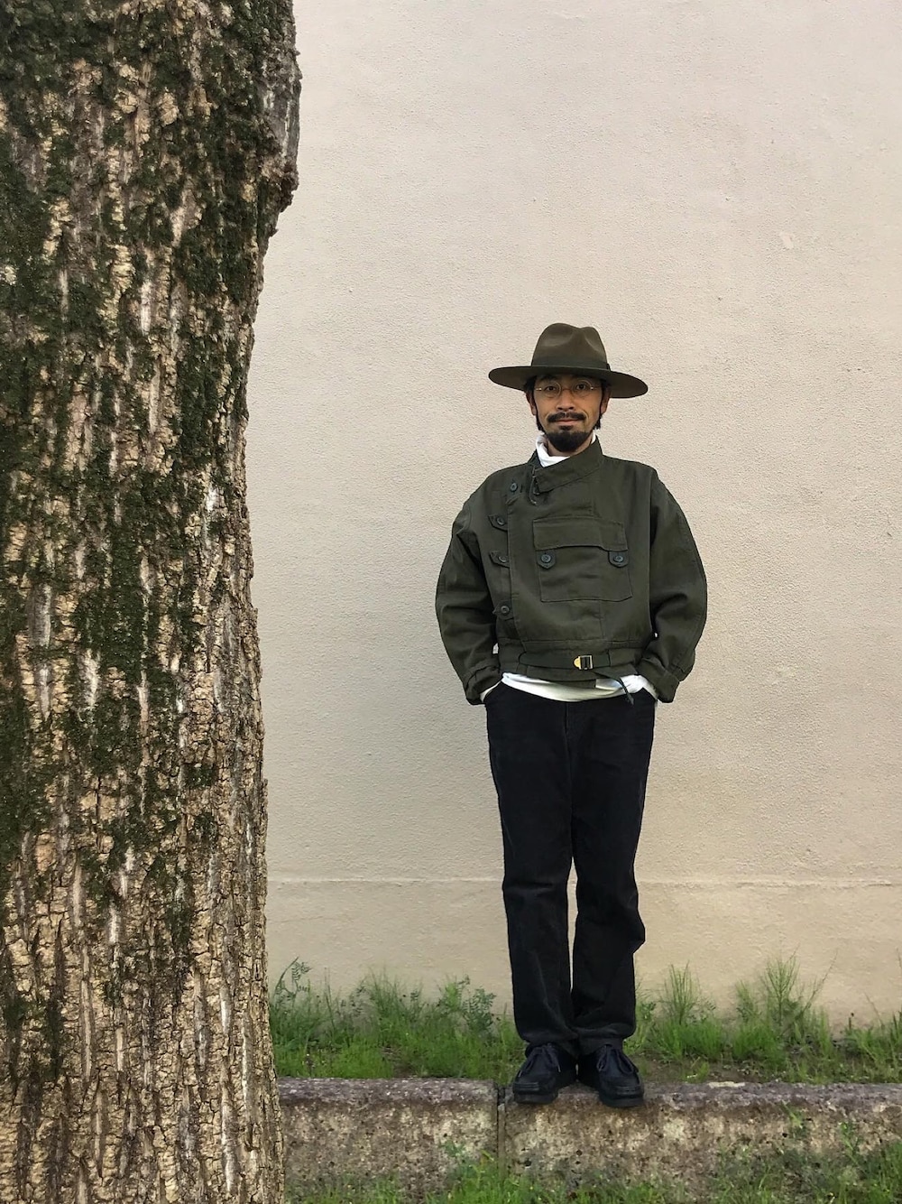 グリーン系のミリタリージャケット、ホワイト系のTシャツ/カットソー、ブラック系のその他パンツを着用したメンズの春コーディネートの1枚目の写真