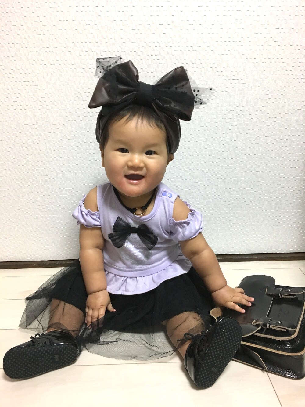 ブラック系のシューズ、ブラック系のショルダーバッグ、ブラック系のネックレスを着用したキッズの春コーディネートの1枚目の写真
