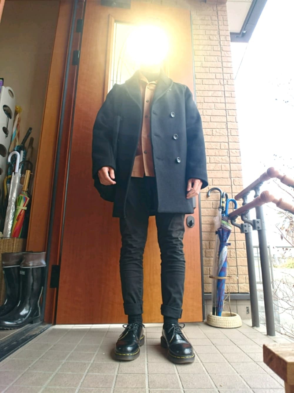 ブラック系のトートバッグ、ブラック系のTシャツ/カットソー、ブラック系のチノパンツを着用したメンズの冬コーディネートの1枚目の写真