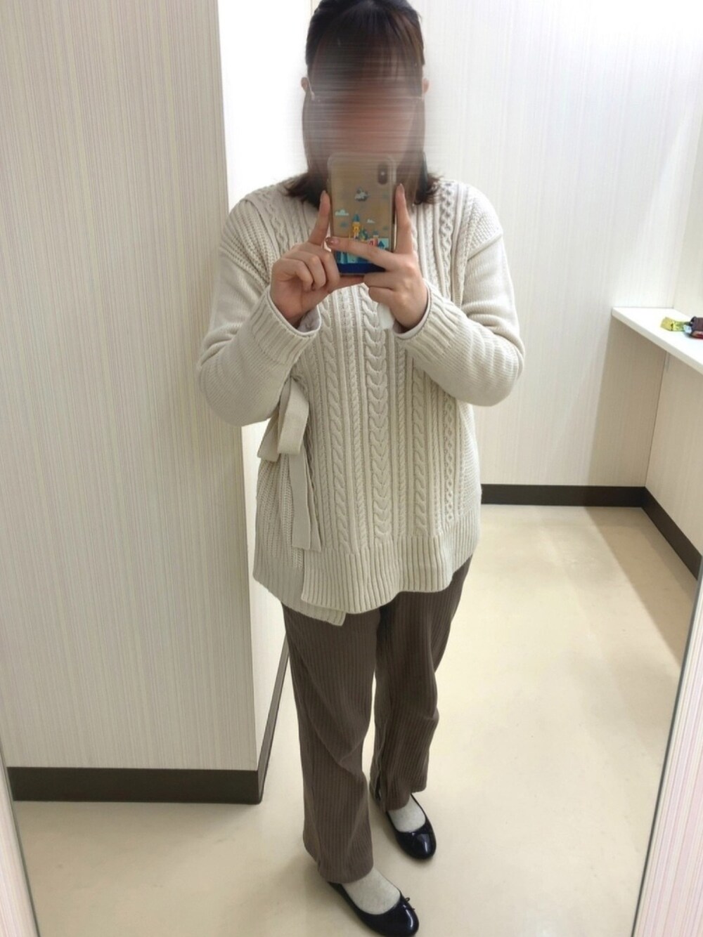 ホワイト系のニット/セーター、ベージュ系のパンツ、ブラック系のバレエシューズを着用したレディースの冬コーディネートの1枚目の写真