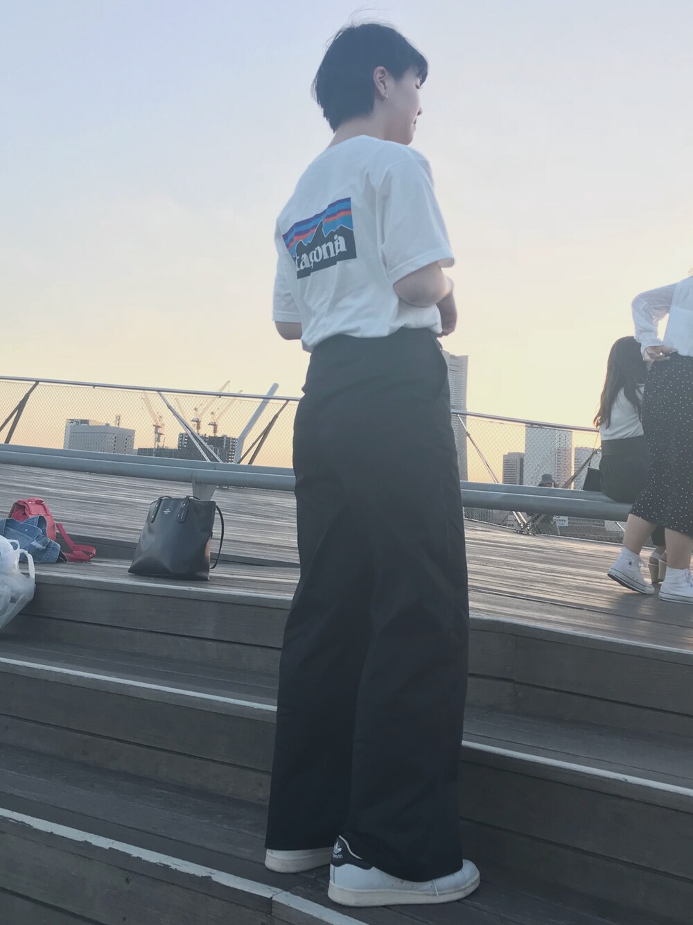 ホワイト系のスニーカー、ブルー系のチノパンツ、ホワイト系のTシャツ/カットソーを着用したレディースの春コーディネートの1枚目の写真