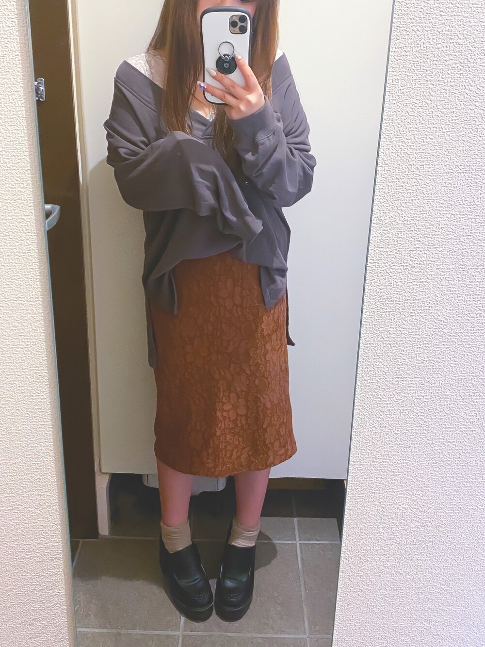 ブラック系のスウェット、ベージュ系のキャミソール、ブラウン系のスカートを着用したレディースの春コーディネートの1枚目の写真