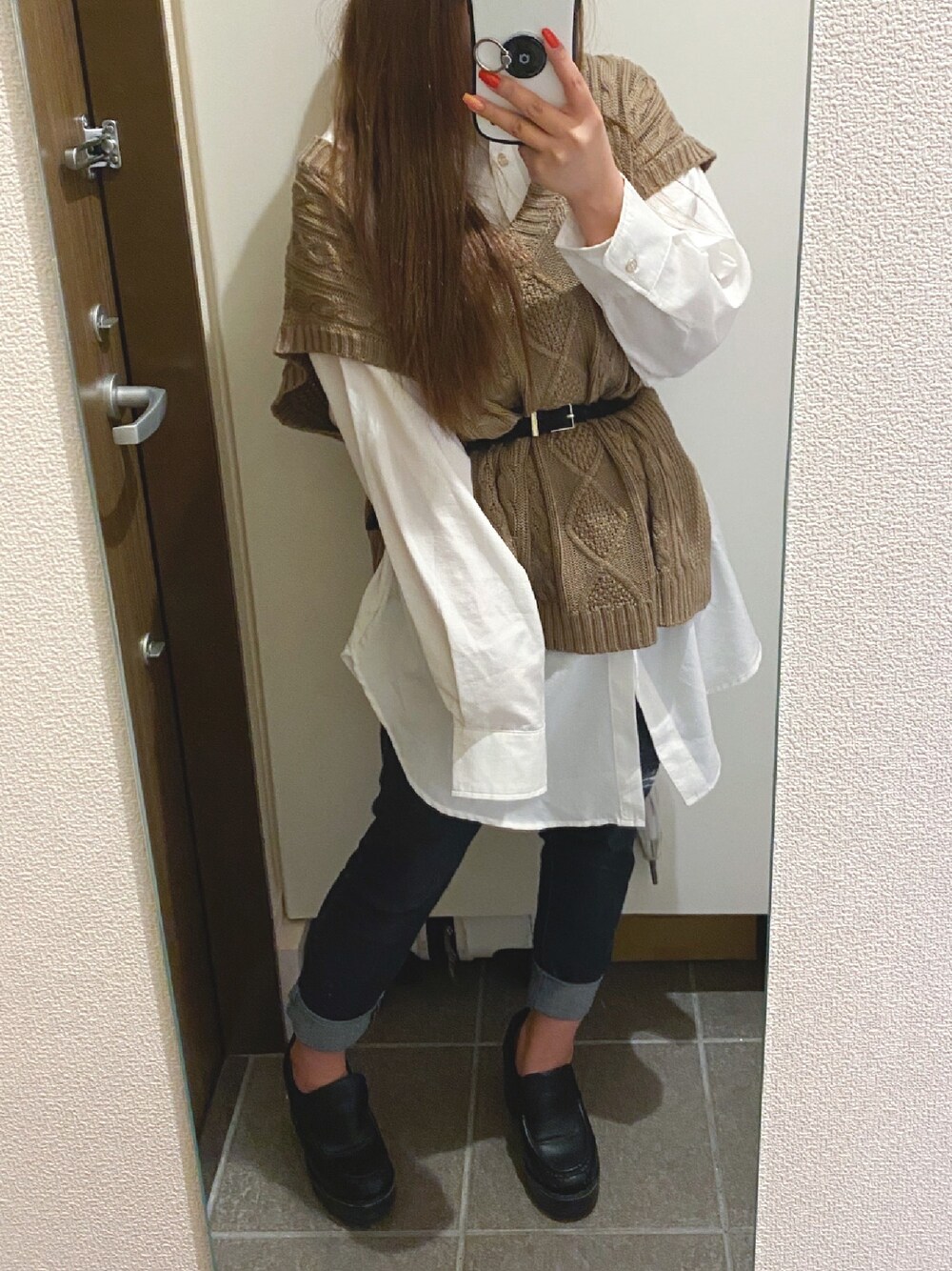 ブラウン系のベスト、ホワイト系のシャツ/ブラウス、ブルー系のデニムパンツを着用したレディースの春コーディネートの1枚目の写真