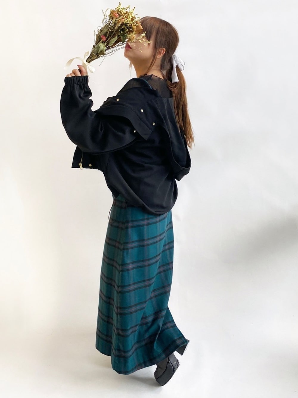 ブラック系のシャツ/ブラウス、ブラック系のマウンテンパーカー、グリーン系のジャンパースカートを着用したレディースの秋コーディネートの1枚目の写真