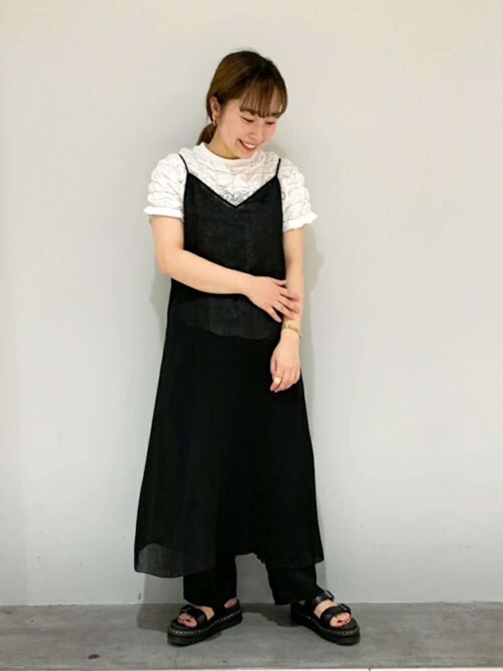 ブラック系のワンピース、ホワイト系のシャツ/ブラウス、ブラック系のその他パンツを着用したレディースの春コーディネートの1枚目の写真
