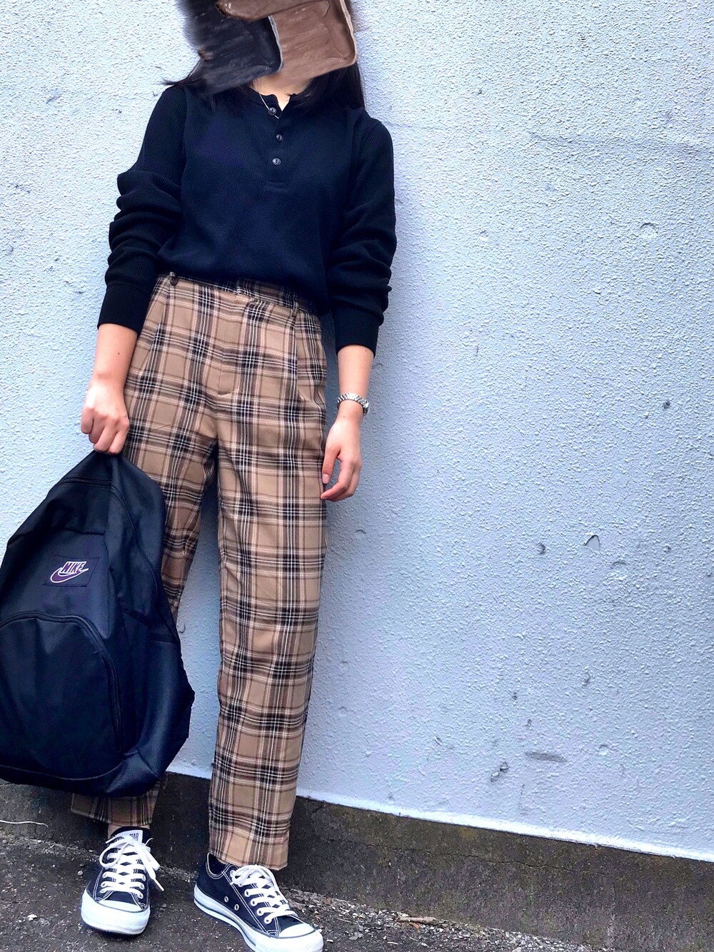 ブラック系のTシャツ/カットソー、ベージュ系のパンツ、ブラック系のスニーカーを着用したレディースの秋コーディネートの1枚目の写真
