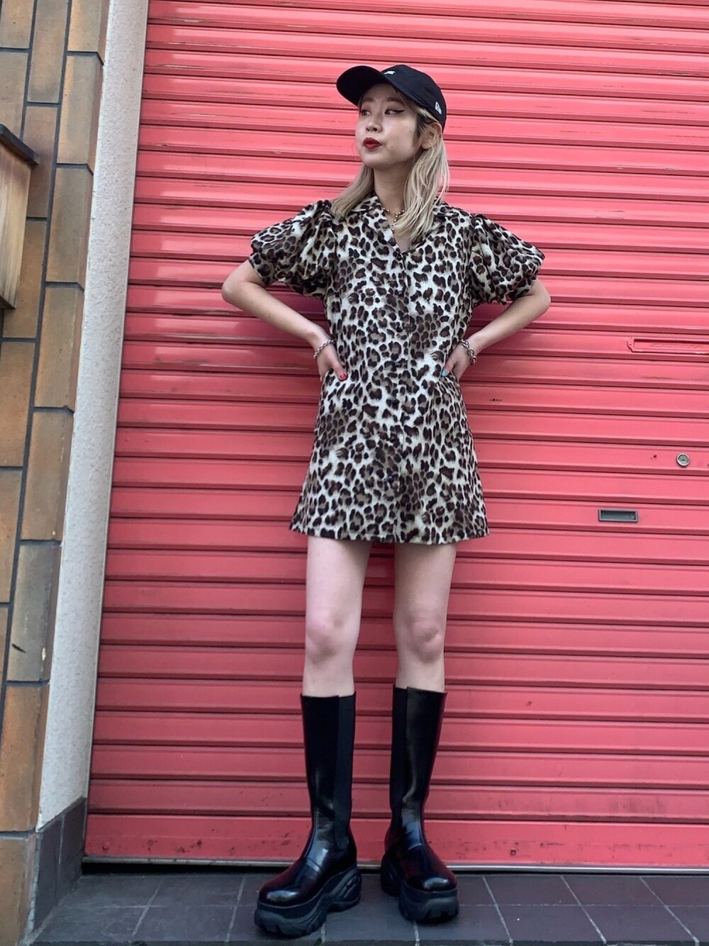 ブラウン系のワンピース、ブラック系のブーツを着用したレディースの春コーディネートの1枚目の写真