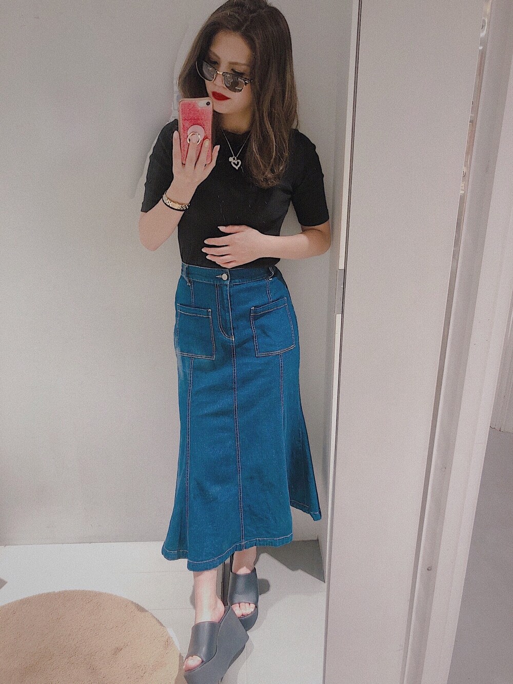 ブラック系のTシャツ/カットソー、ブルー系のスカート、ブラック系のサンダルを着用したレディースの夏コーディネートの1枚目の写真