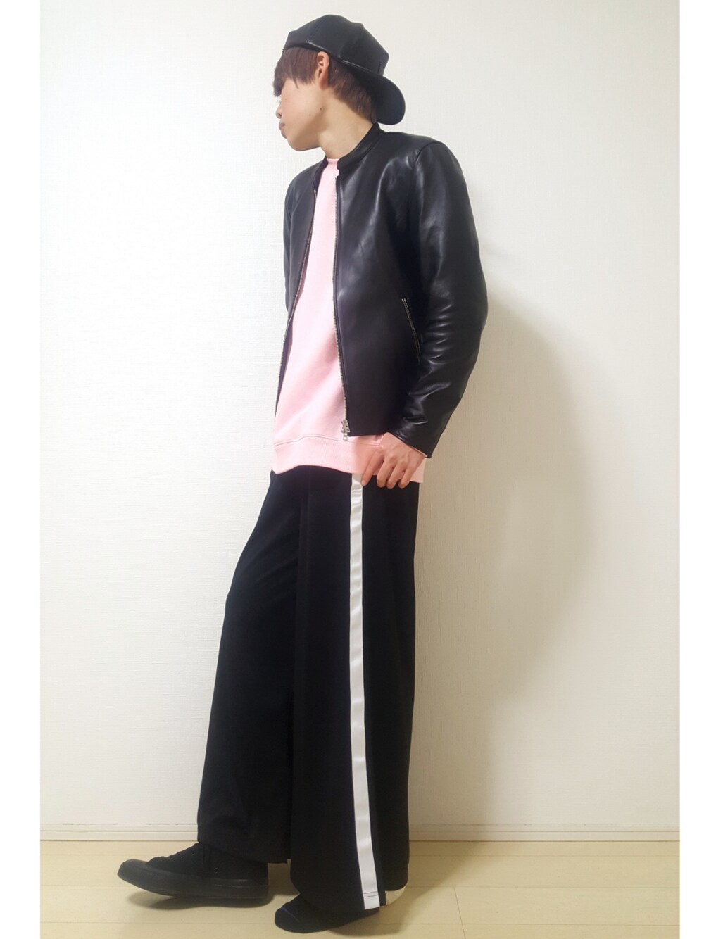 ブラック系のその他パンツ、ブラック系のライダースジャケット、ピンク系のスウェットを着用したメンズの冬コーディネートの1枚目の写真