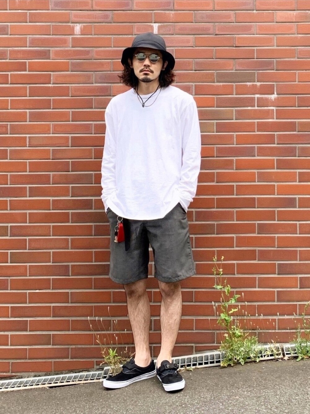 ホワイト系のTシャツ/カットソー、グレー系のパンツ、ブラック系のスニーカーを着用したメンズの春コーディネートの1枚目の写真