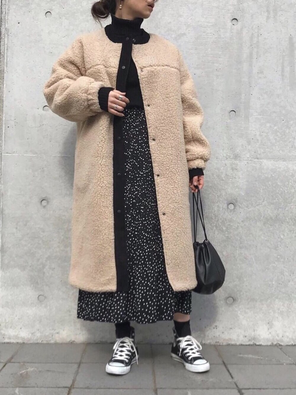 ブラック系のニット/セーター、ブラック系のスニーカー、ベージュ系のその他アウターを着用したレディースの冬コーディネートの1枚目の写真