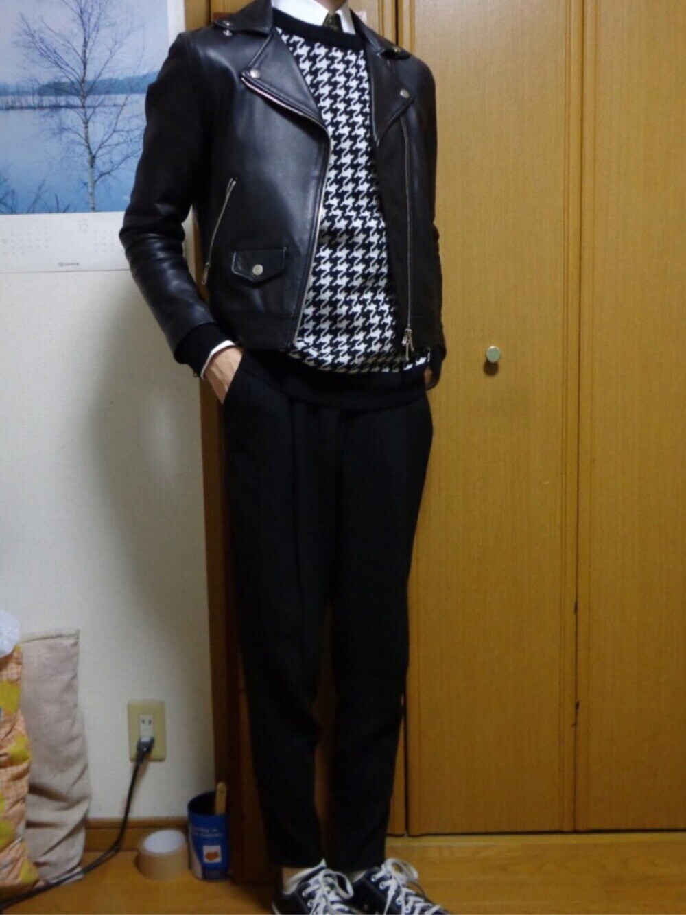 ブラック系のライダースジャケット、ブラック系のスラックス、ブラック系のスニーカーを着用したメンズの冬コーディネートの1枚目の写真