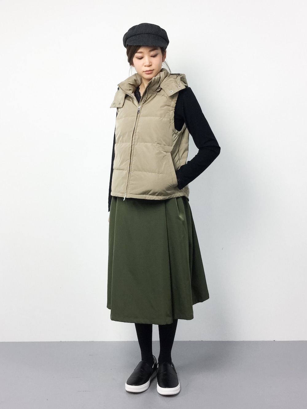 ベージュ系のダウンベストを着用したレディースの冬コーディネートの1枚目の写真