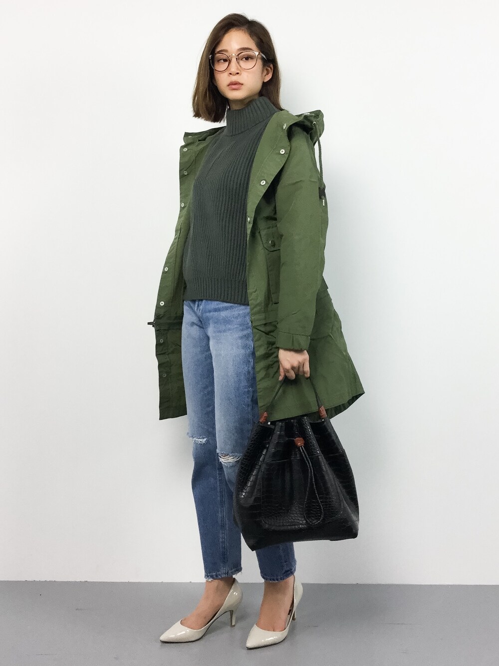 グリーン系のニット/セーター、ブルー系のデニムパンツ、グリーン系のマウンテンパーカーを着用したレディースの冬コーディネートの1枚目の写真