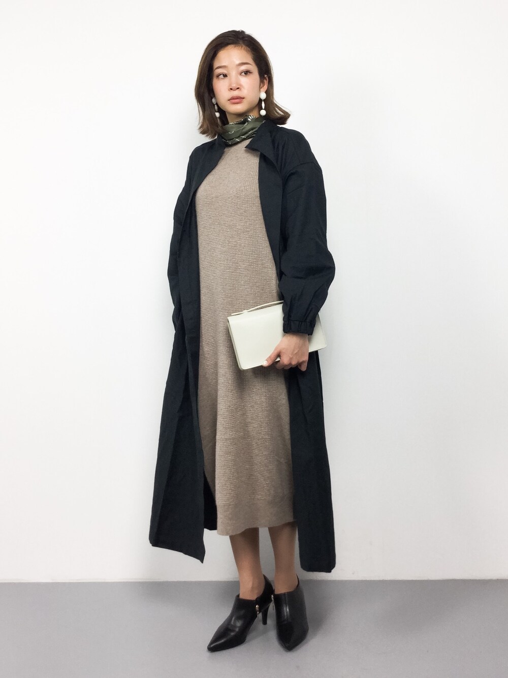 ベージュ系のワンピース、ブラック系のその他アウター、ホワイト系のショルダーバッグを着用したレディースの春コーディネートの1枚目の写真