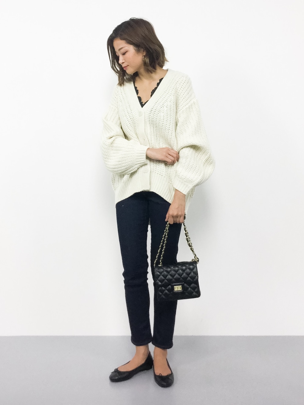 ホワイト系のカーディガン/ボレロ、ブルー系のデニムパンツを着用したレディースの秋コーディネートの1枚目の写真